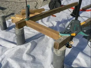 On utilise des serre-joints à mors longs pour aligner l’entretoise sur les deux lambourdes